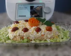 Step <p>Desmolde el pudin, cubra con la mayonesa y decore con los pepinillos, las aceitunas y el huevo duro en rodajas o rallado. Corte en porciones y sirva.</p> illustration