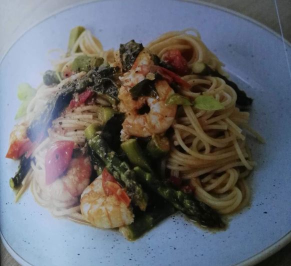 Espaguetis con espárragos, tomates y langostinos.